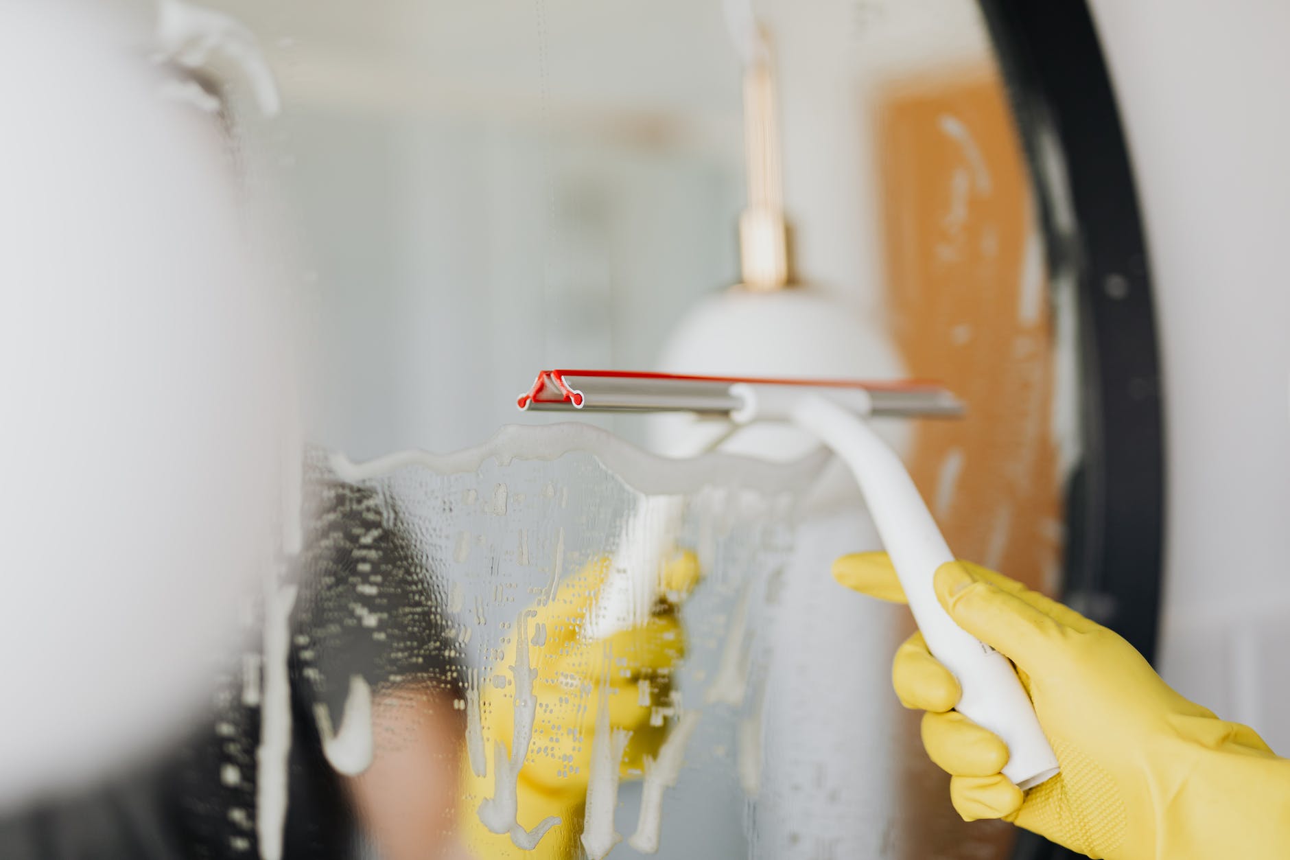 faceless person removing water from mirror