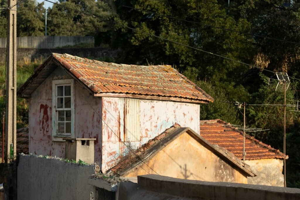 Charming old cottage with red tiles in a rural setting, captured in golden sunlight.