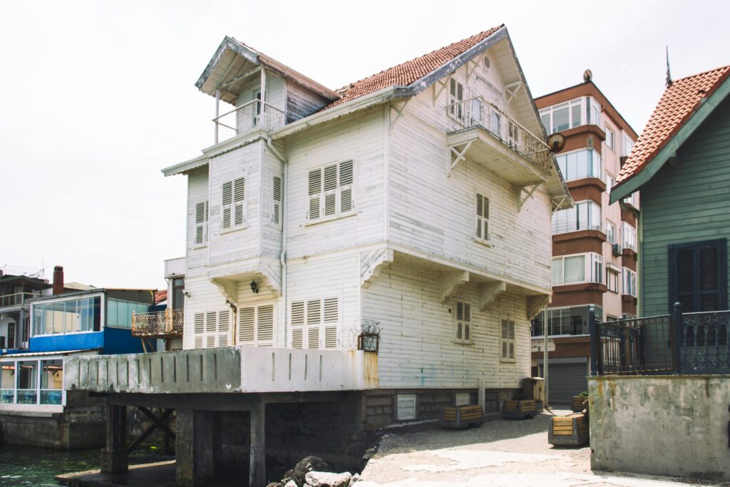 Historic white wooden house on the waterfront, showcasing traditional coastal architecture.