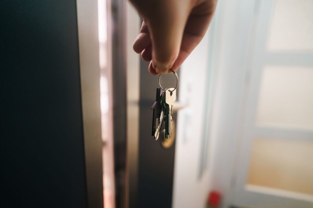 hand holding keys at doorway in new home