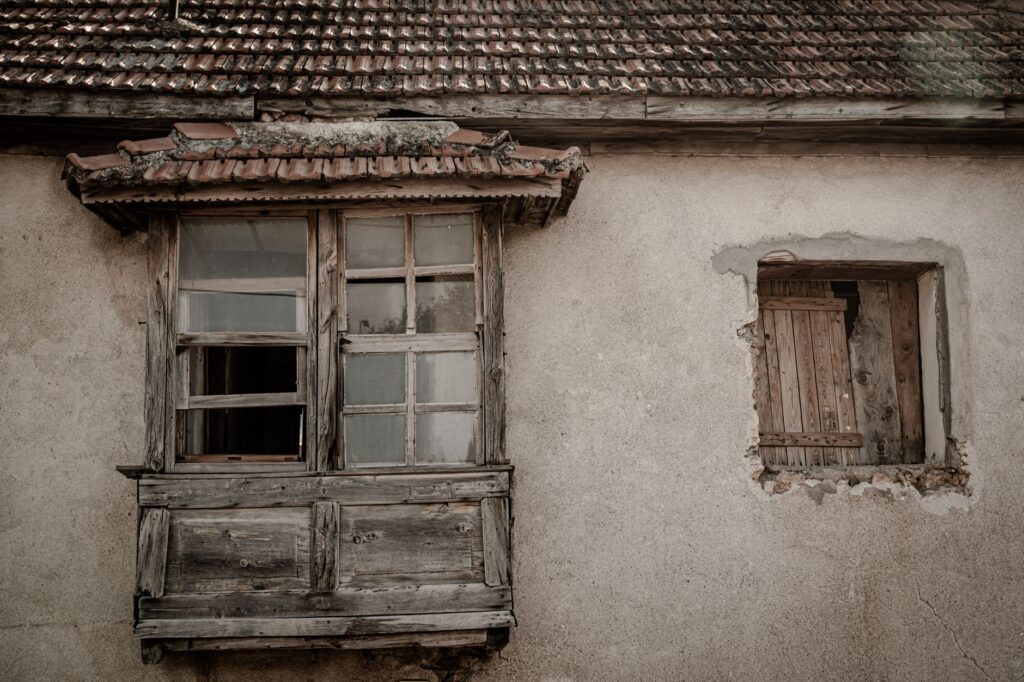 an old concrete house with broken window